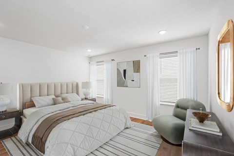 A bedroom with a large bed and a chair.
