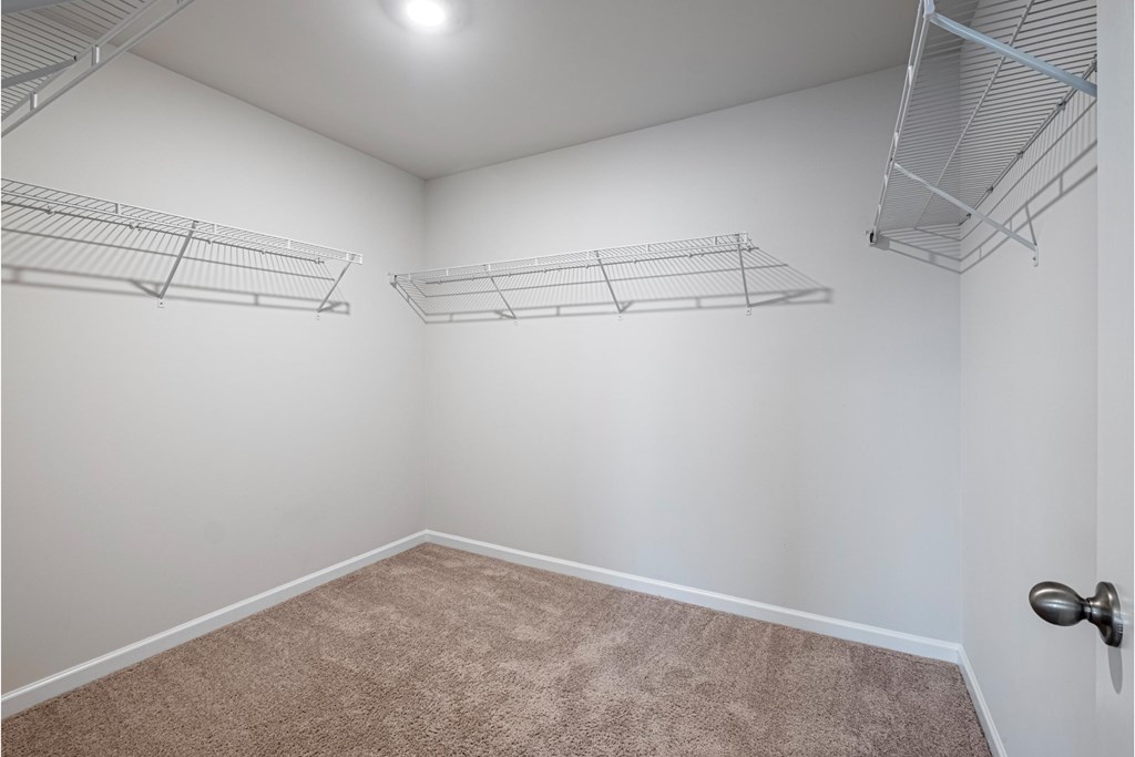 an empty room with two shelves on the wall and a carpet