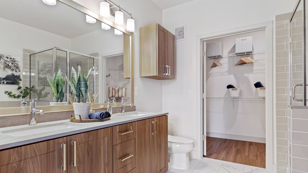 Bathroom with dual vanity and attached walk-in closet