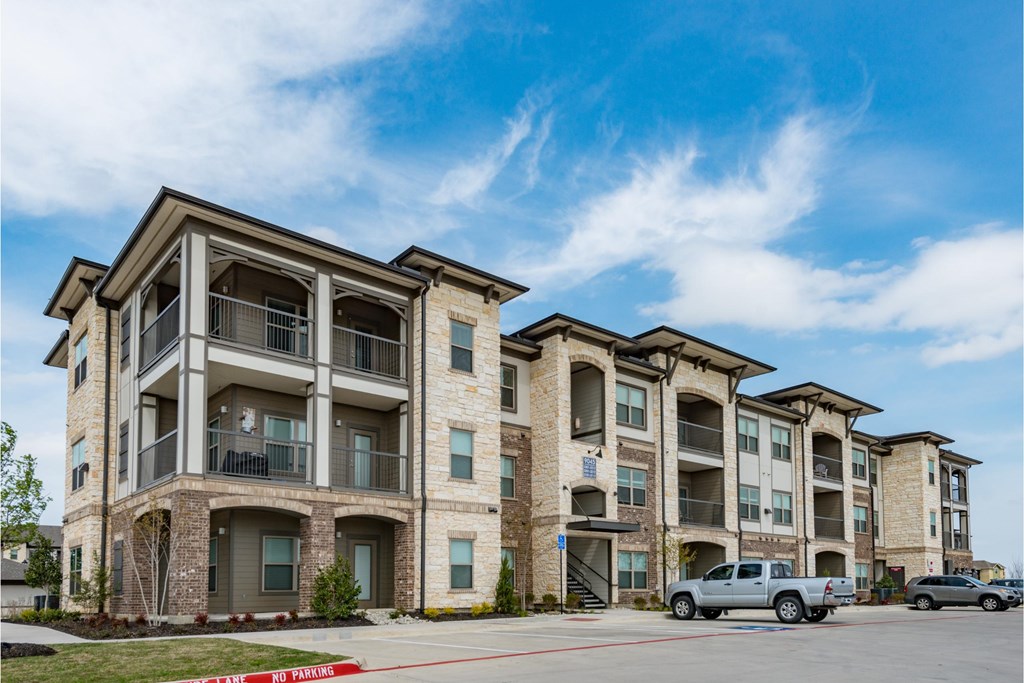 an apartment building with cars parked in front of it