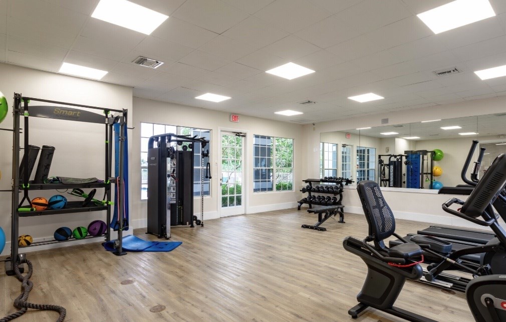 A gym with a variety of equipment including treadmills, weights, and exercise machines.