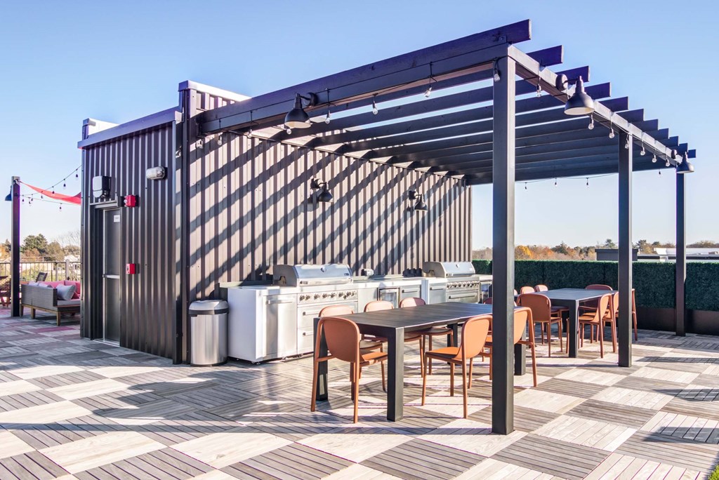 The Beacon rooftop grill and dining area with pergola covering and hanging lights