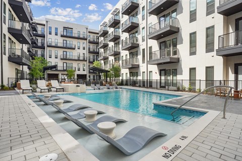 A pool surrounded by apartment buildings with a no swimming sign.