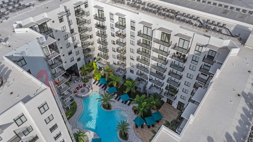 A large white building with a pool in the middle of it.