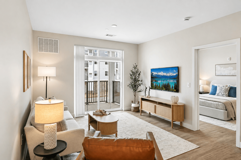 A well-lit living room with a brown chair and a white couch.