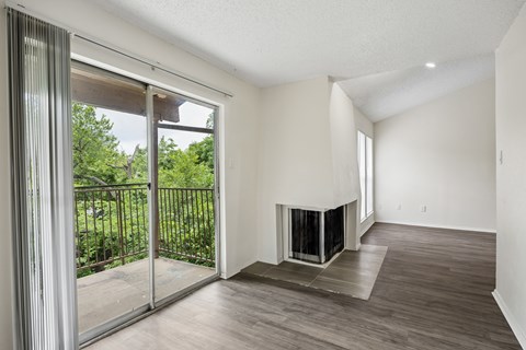 A modern living room with a fireplace and sliding glass doors.