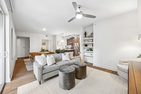 A living room with a grey couch and a grey ottoman.