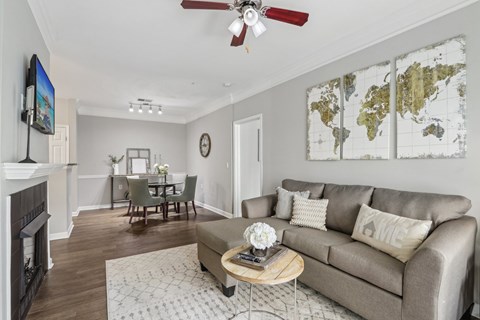 A living room with a grey couch, a coffee table, a fireplace, and a world map on the wall.