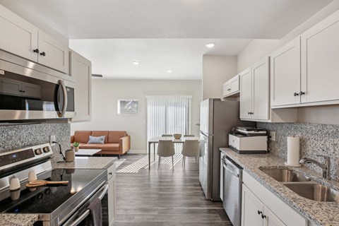A modern kitchen with a black stove top oven and a marble counter top.