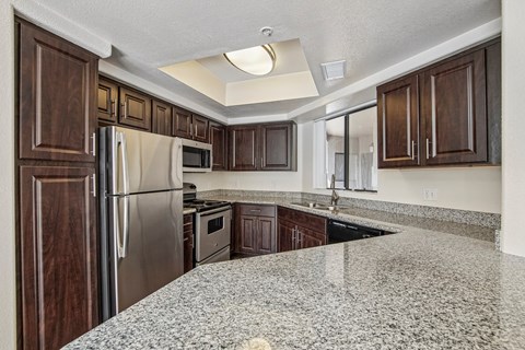 A kitchen with granite countertops and stainless steel appliances.