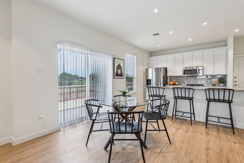 A modern kitchen with a dining table and chairs.