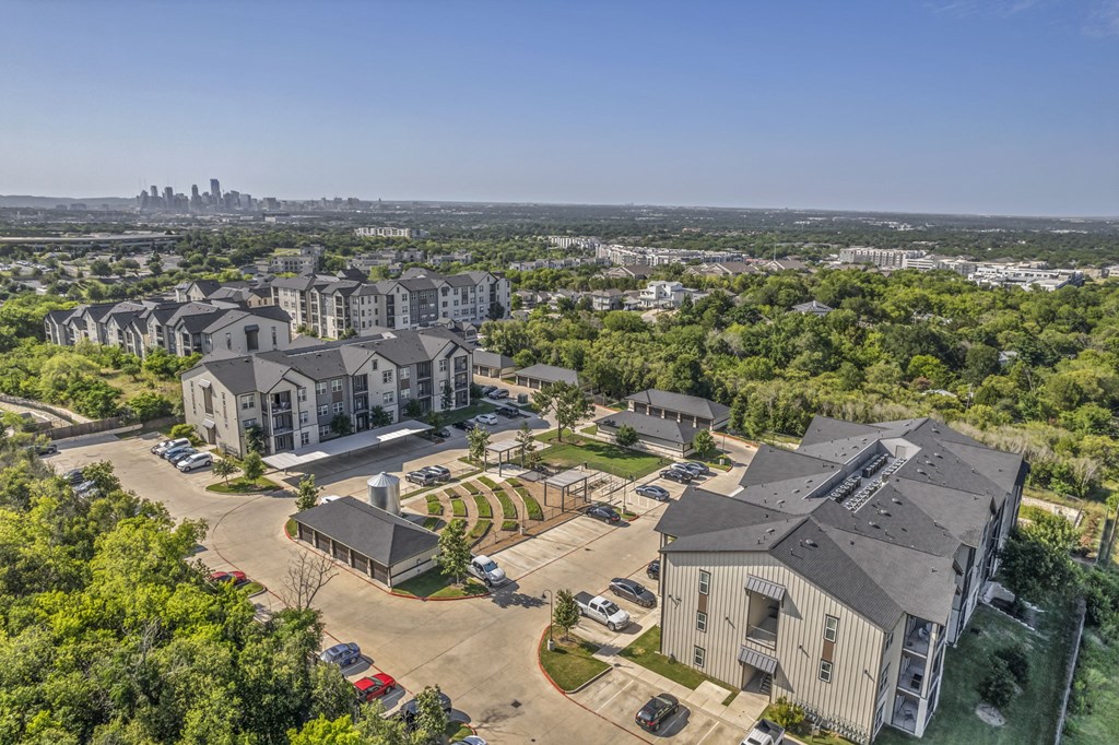 an aerial view of houses in a neighborhood with a city in the background