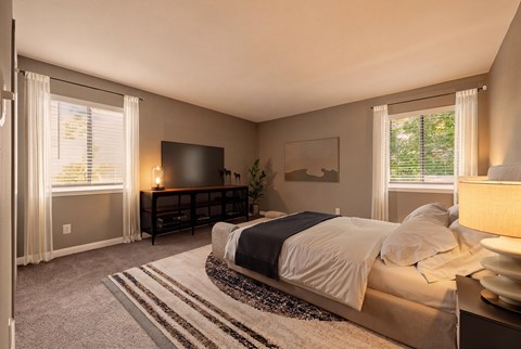 A bedroom with a bed, a dresser, and a window with curtains.