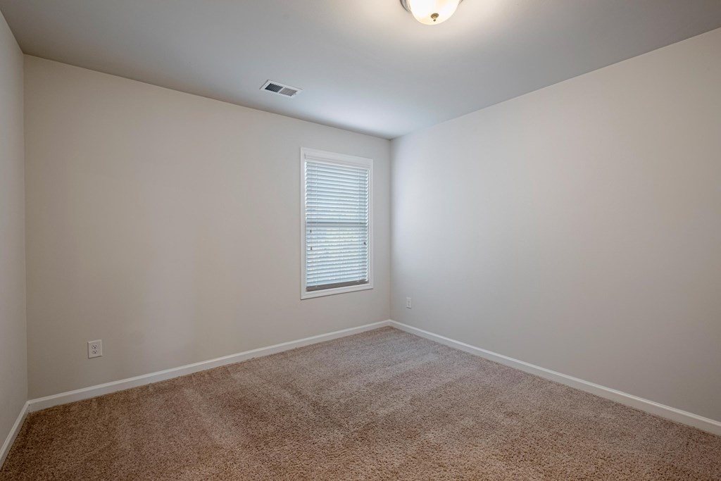 a empty room with a window and carpeting