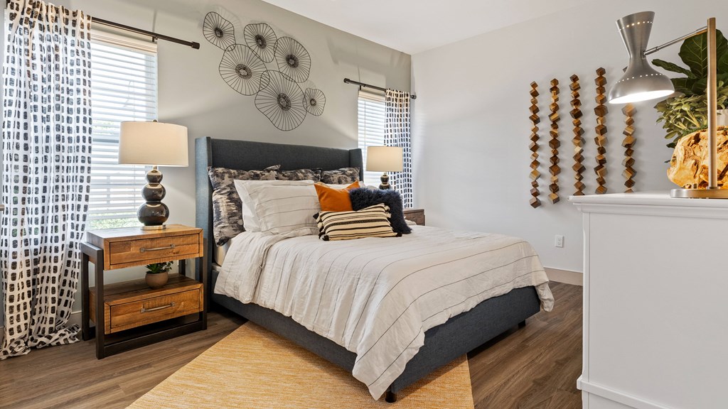 Bedroom with woodstyle flooring and large windows