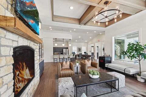 A modern living room with a stone fireplace and a large painting above it.