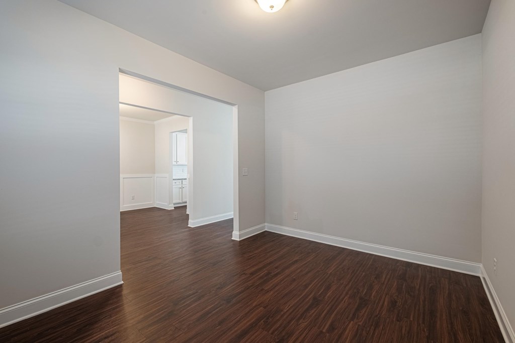 an empty living room with white walls and wood flooring