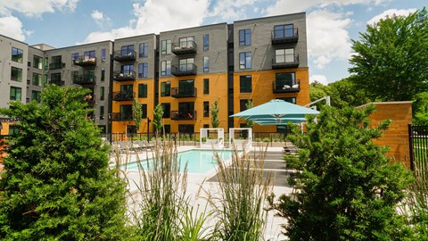 A large apartment complex with a pool in the foreground.