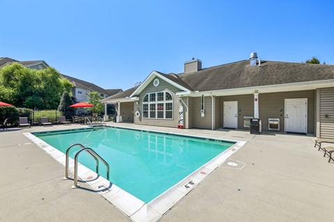 A swimming pool in a residential area with a house in the background.