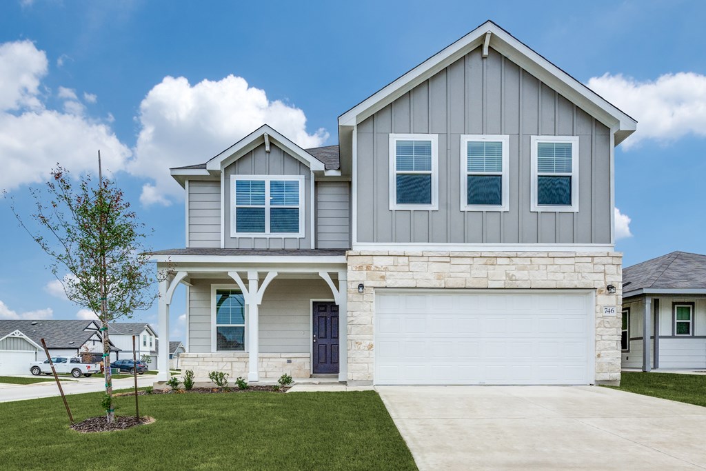 A modern house with a grey facade and a white garage door.