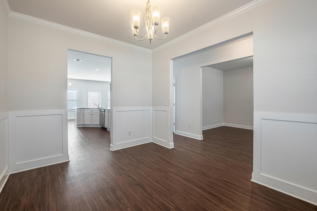 a living room and dining room with white walls and wood flooring