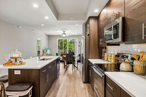 A modern kitchen with dark wood cabinets and white countertops.