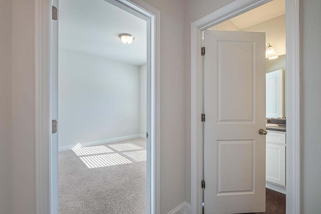 a bedroom with a white door and a carpeted floor