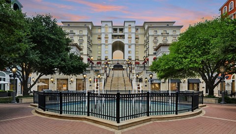 A large building with a pool in front of it.