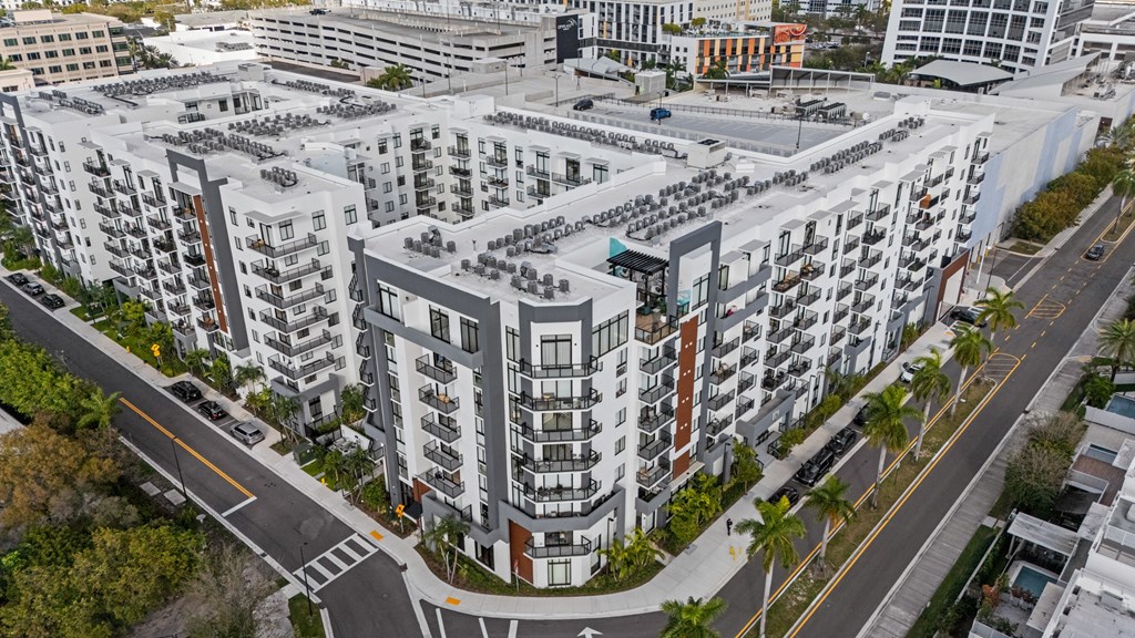 A large apartment complex with a parking lot in front.