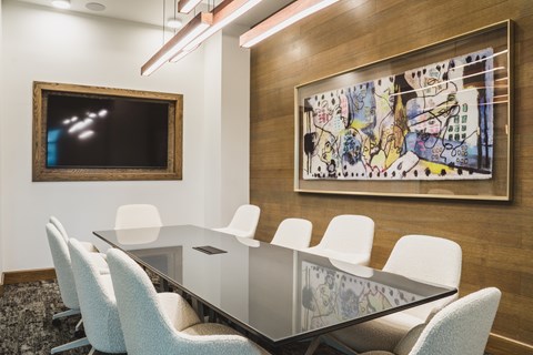 A conference room with a glass table and chairs.