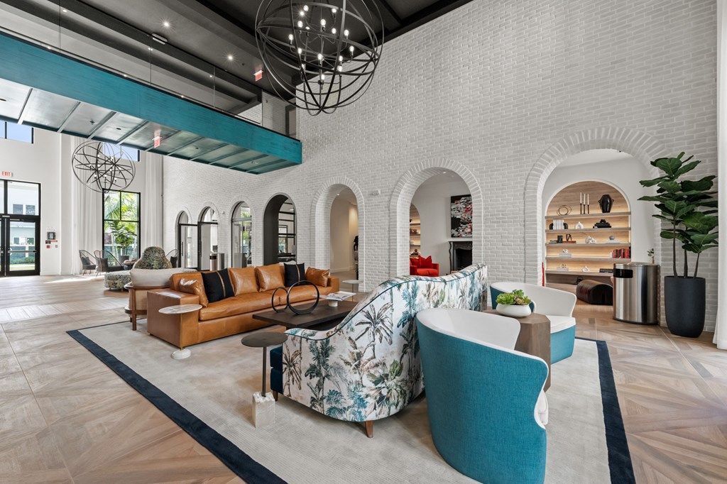 A modern lobby with a white brick wall and a large circular light fixture.