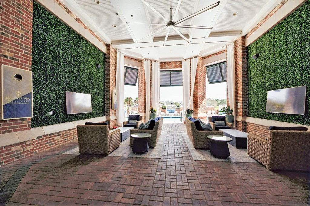 a lobby with couches and tables and a brick wall