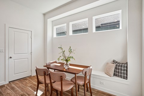 A dining room with a table and chairs.
