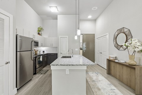 A modern kitchen with a central island and stainless steel appliances.