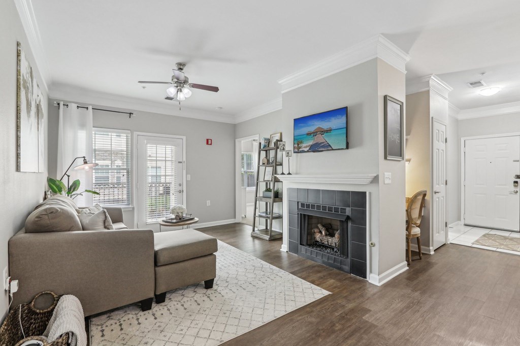 A living room with a grey couch and a fireplace.