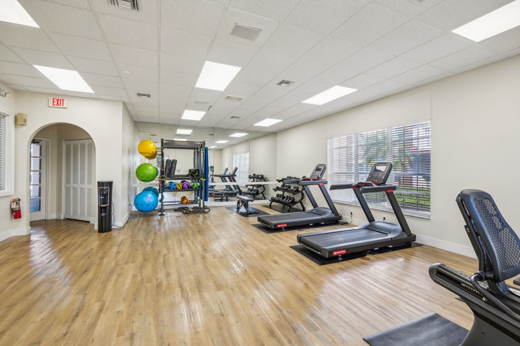 A gym with treadmills, exercise balls, and other equipment.