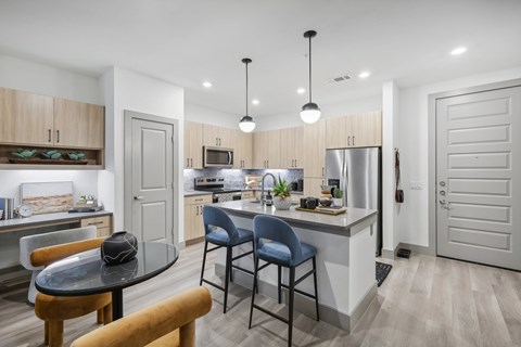 A modern kitchen with a dining table and chairs.