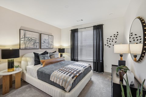 A bedroom with a large bed and a mirror on the wall.