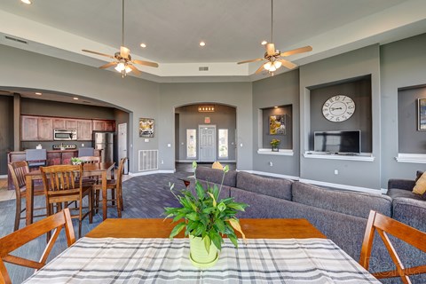 A dining room with a table and chairs and a plant on the table.