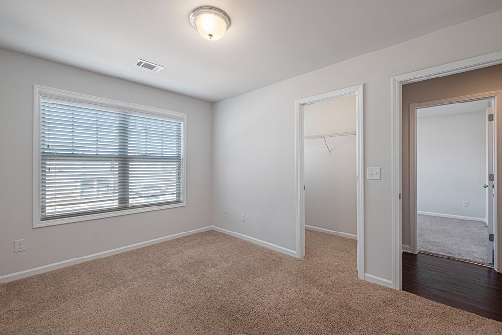 an empty room with a large window and a door