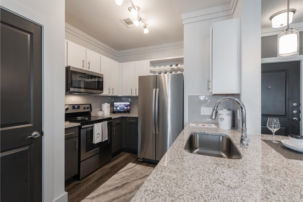 a kitchen with granite counter tops and stainless steel appliances