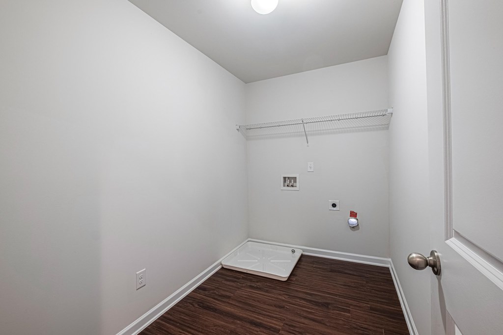 a bedroom with white walls and wood flooring and a white door