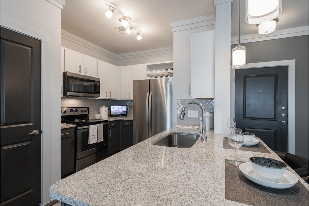 a kitchen with granite counter tops and black appliances