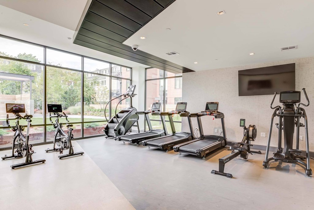 A gym with treadmills, exercise bikes, and elliptical machines.
