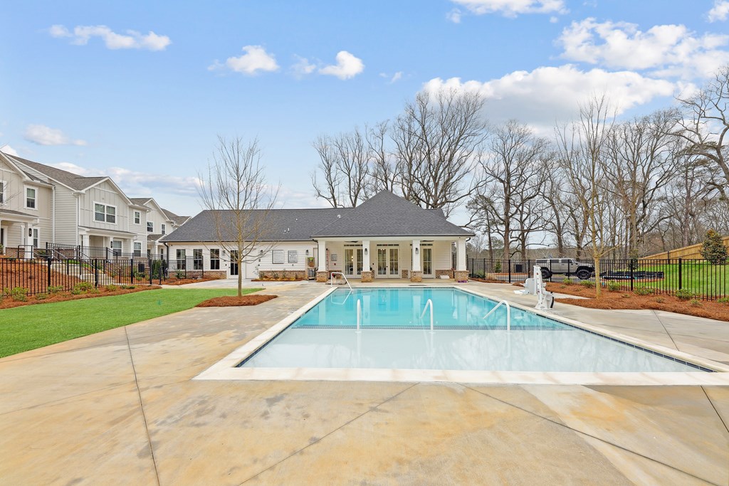 a swimming pool with a house in the background