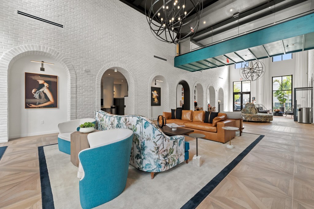 A living room with a white brick wall and a large painting of a woman.