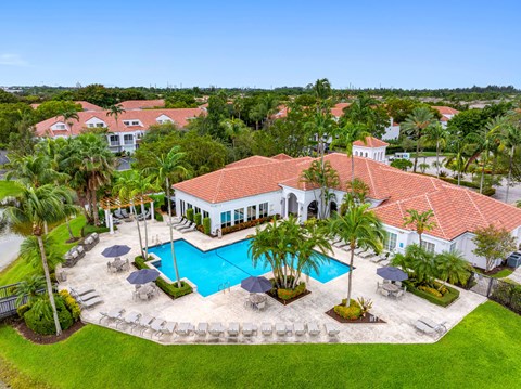 A large house with a pool in the middle of a grassy area.
