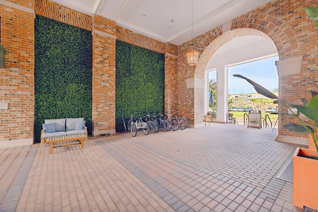 a brick building with a green wall and bikes parked in front of it