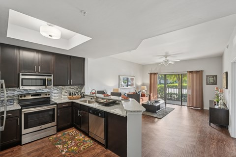 A modern kitchen with dark wood cabinets and stainless steel appliances.