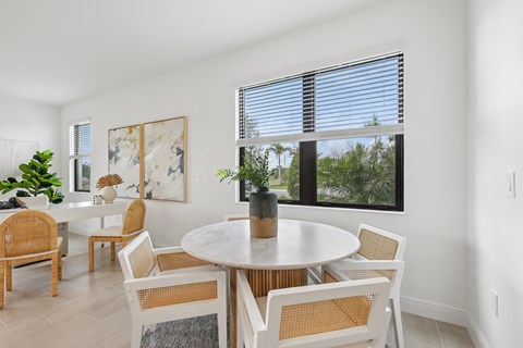 A dining room with a round table and chairs.